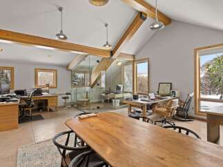 Experience a productive workspace with stunning natural light and scenic winter views through large wooden-framed windows.