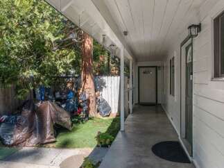 Discover this charming property featuring a covered porch leading to multiple entrances, perfect for welcoming guests.