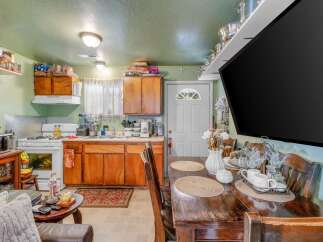 This charming kitchen and dining area offers a functional layout with ample cabinet space and a full-size gas range.