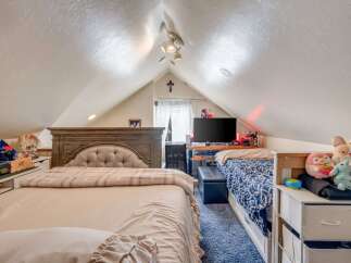 This charming attic bedroom offers a cozy and functional living space, perfect for a guest room or a child's retreat.