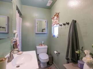 This bathroom features a light green painted wall and a white sink with a silver faucet.