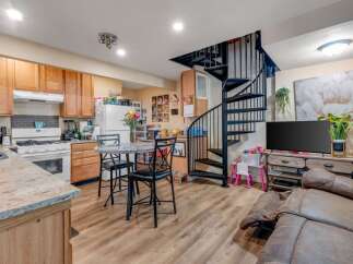 This charming home features a functional kitchen with ample cabinet space and a cozy dining area perfect for intimate meals.