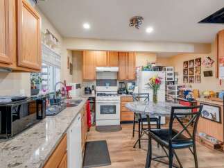 This charming kitchen features warm wooden cabinetry and granite countertops, offering ample storage and workspace.