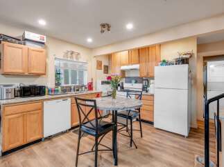 This charming kitchen features light wood cabinetry and granite countertops, offering ample storage and a spacious feel.