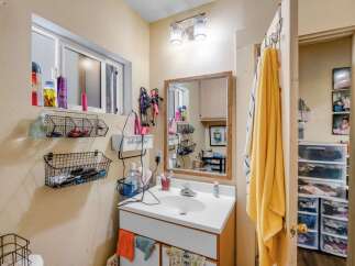 This bathroom features a white vanity with a sink and a wooden-framed mirror.