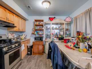 This charming kitchen features light wood cabinetry, a stainless steel gas range, and a built-in microwave.