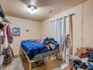 This bedroom features a comfortable bed with a blue comforter, perfect for a cozy retreat.
