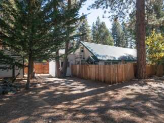 Discover this charming property nestled among mature pine trees, offering a serene and private backyard oasis.