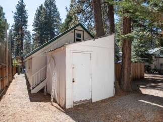 Discover this charming property featuring a detached white shed with a white door, perfect for storage or a workshop.