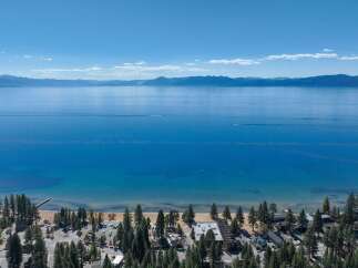 Experience breathtaking lakefront living with this stunning aerial view of a property nestled along the pristine shores of a vast, blue lake.