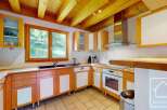 This charming kitchen features warm wooden cabinetry with white accents, complemented by a spacious wooden countertop.