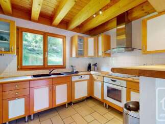 This charming kitchen features warm wooden cabinetry with white accents, complemented by a spacious wooden countertop.
