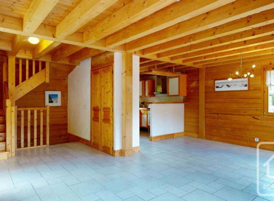 Experience the charm of this rustic wooden chalet, featuring a cozy staircase and an open-plan living area.