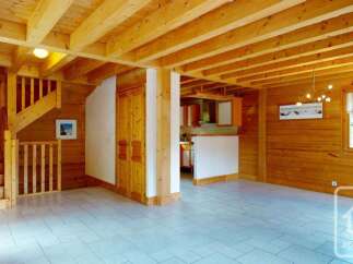 Experience the charm of this rustic wooden chalet, featuring a cozy staircase and an open-plan living area.