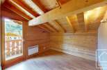 Experience rustic charm in this attic room, featuring exposed wooden beams and paneling that create a warm, inviting atmosphere.