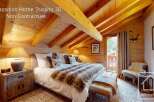 Experience the charm of this cozy mountain bedroom, featuring a luxurious king-size bed adorned with a plush fur throw.