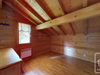 Experience cozy living in this charming wooden attic room, featuring exposed beams and a warm, natural wood finish throughout.