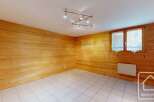 Experience cozy living in this charming room featuring warm, wood-paneled walls and a bright, tiled floor.