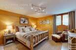 Experience cozy mountain living in this charming bedroom, featuring a rustic log bed adorned with plush bedding and a faux fur throw.