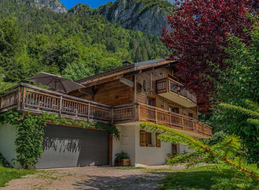 Experience the charm of this stunning wooden chalet nestled against a majestic mountain backdrop.