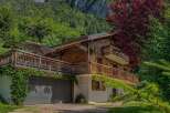 Experience the charm of this stunning wooden chalet nestled against a majestic mountain backdrop.