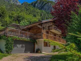 Experience the charm of this stunning wooden chalet nestled against a majestic mountain backdrop.