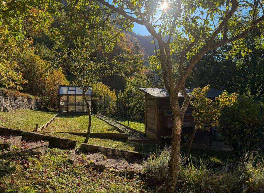 Discover this charming property featuring a quaint greenhouse and a rustic wooden shed, perfect for gardening enthusiasts.