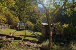 Discover this charming property featuring a quaint greenhouse and a rustic wooden shed, perfect for gardening enthusiasts.