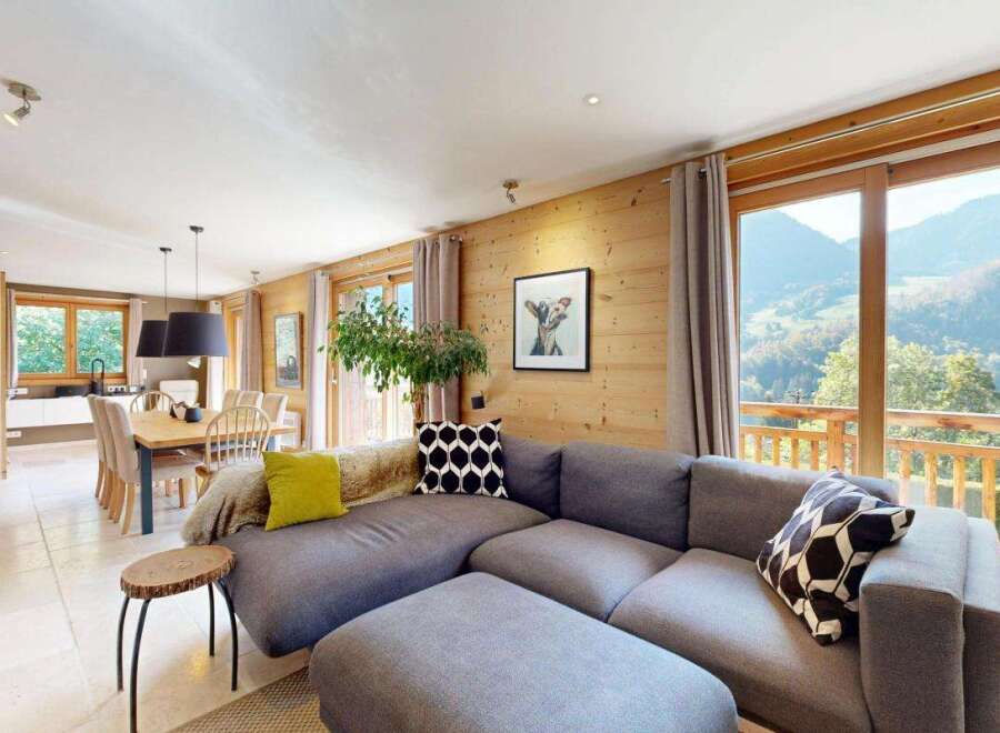 Experience breathtaking mountain views from this stunning living room, featuring a spacious sectional sofa and a cozy dining area.