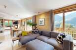 Experience breathtaking mountain views from this stunning living room, featuring a spacious sectional sofa and a cozy dining area.