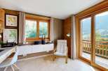 This charming room offers a dedicated workspace with a desk, printer, and shelving, perfect for remote work or study.