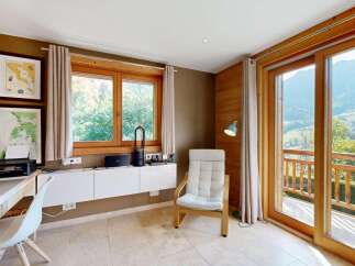 This charming room offers a dedicated workspace with a desk, printer, and shelving, perfect for remote work or study.