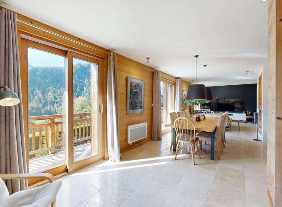 Experience breathtaking mountain views from this stunning chalet, featuring expansive glass doors that open onto a private balcony.