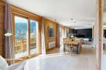 Experience breathtaking mountain views from this stunning chalet, featuring expansive glass doors that open onto a private balcony.
