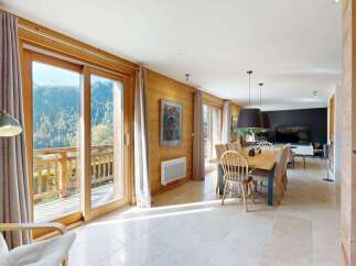 Experience breathtaking mountain views from this stunning chalet, featuring expansive glass doors that open onto a private balcony.