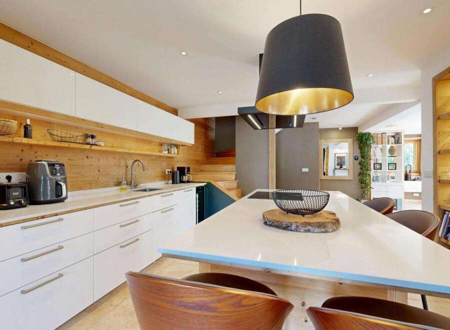 Experience modern living in this stunning kitchen featuring sleek white cabinetry and warm wood accents.