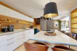 Experience modern living in this stunning kitchen featuring sleek white cabinetry and warm wood accents.