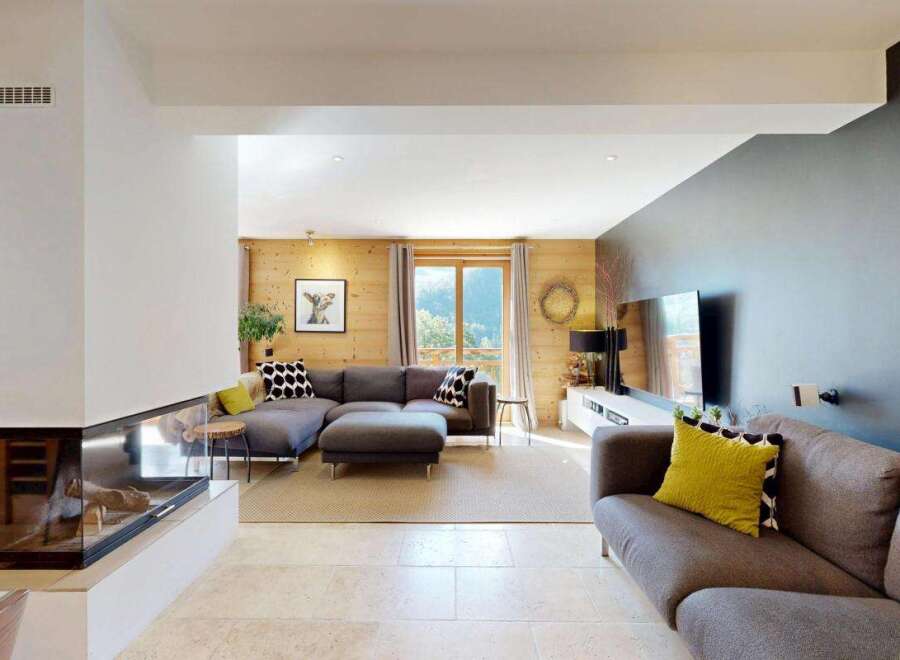 Experience modern living in this spacious living room, featuring a sleek gas fireplace and a large sectional sofa perfect for relaxation.