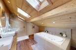 Experience luxury in this stunning attic bathroom, featuring a spacious soaking tub and a separate walk-in shower.