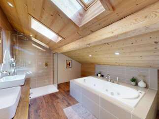 Experience luxury in this stunning attic bathroom, featuring a spacious soaking tub and a separate walk-in shower.