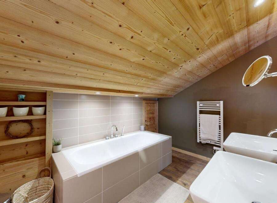 Experience rustic luxury in this stunning bathroom, featuring a spacious bathtub and dual sinks.
