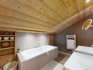 Experience rustic luxury in this stunning bathroom, featuring a spacious bathtub and dual sinks.