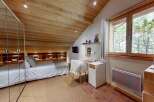 Experience cozy living in this charming bedroom featuring a comfortable bed, built-in shelving, and a dedicated workspace.