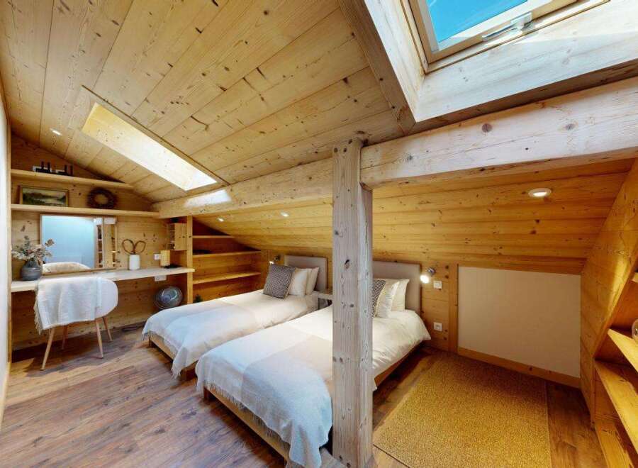 Experience cozy mountain living in this charming attic bedroom, featuring two comfortable twin beds perfect for guests or family.