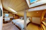 Experience cozy mountain living in this charming attic bedroom, featuring two comfortable twin beds perfect for guests or family.