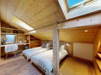 Experience cozy mountain living in this charming attic bedroom, featuring two comfortable twin beds perfect for guests or family.