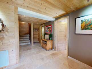 Step into a warm and inviting entryway featuring natural wood paneling and a charming pinecone wreath.