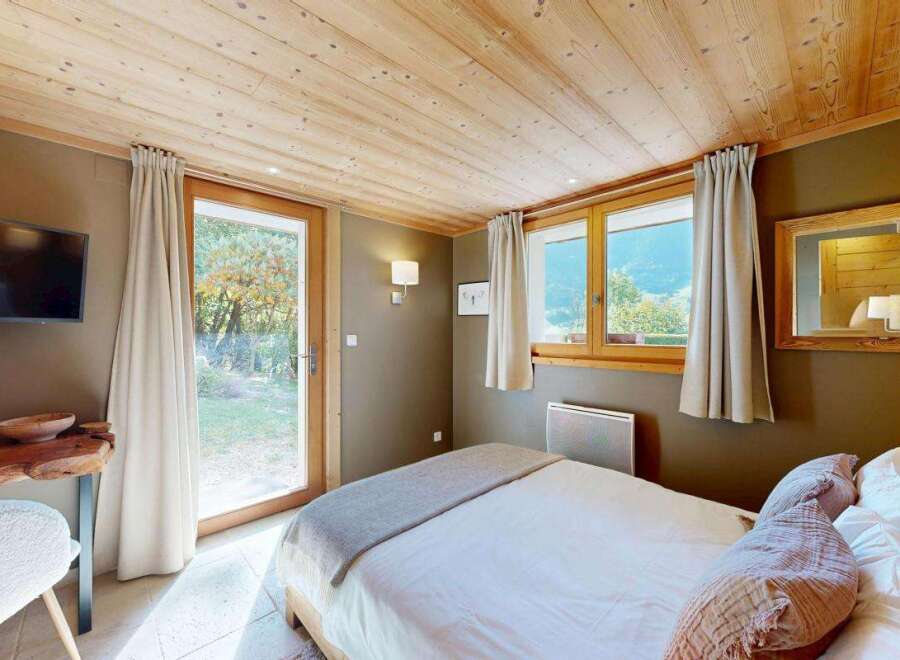 Experience cozy mountain living in this charming bedroom featuring a comfortable bed adorned with plush pillows and a soft throw.