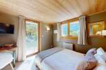 Experience cozy mountain living in this charming bedroom featuring a comfortable bed adorned with plush pillows and a soft throw.