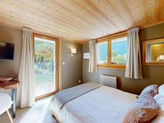 Experience cozy mountain living in this charming bedroom featuring a comfortable bed adorned with plush pillows and a soft throw.